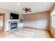 Cozy living room featuring a stone fireplace, hardwood floors, a ceiling fan, and built-in shelving at 13744 Columbine St, Thornton, CO 80602