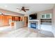 Open-concept living room with a stone fireplace, hardwood floors, and a view into the kitchen area at 13744 Columbine St, Thornton, CO 80602