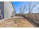 Side view of the backyard featuring a wood fence and shade trees at 291 Las Lomas St, Brighton, CO 80601