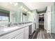 Bright bathroom featuring a double vanity with gray cabinets, a walk-in closet, and gray tile flooring at 291 Las Lomas St, Brighton, CO 80601