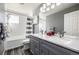 Updated bathroom with gray cabinets, a double vanity, and a shower-tub combination at 291 Las Lomas St, Brighton, CO 80601