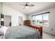 The bedroom features carpet flooring, a ceiling fan, light green walls, and a large window overlooking the neighborhood at 291 Las Lomas St, Brighton, CO 80601