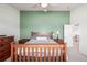 This bedroom features carpet flooring, green accent wall, a ceiling fan, and classic wooden furniture at 291 Las Lomas St, Brighton, CO 80601