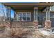 Inviting covered front porch featuring brick columns and a cozy seating area at 291 Las Lomas St, Brighton, CO 80601