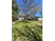 View of back of house and deck from grassy backyard featuring mature trees and landscaping at 10064 W Lake Dr, Littleton, CO 80127