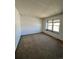 Bedroom with neutral-colored carpet, a large window, and blank white walls at 10064 W Lake Dr, Littleton, CO 80127