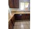Kitchen area featuring a beige countertop, a sink with a window, and dark brown wooden cabinets at 10064 W Lake Dr, Littleton, CO 80127