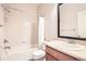 Bathroom featuring tiled shower and sink with a large mirror at 13001 Grant Cir # C, Thornton, CO 80241