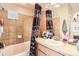 This bathroom features tile walls surrounding the tub and vanity, and a modern shower curtain at 13001 Grant Cir # C, Thornton, CO 80241