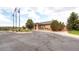Exterior shot of the club house featuring mature landscaping and three flag poles at 13001 Grant Cir # C, Thornton, CO 80241