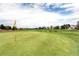 Expansive view of the lush green golf course showcasing a well-manicured lawn and distant residential homes at 13001 Grant Cir # C, Thornton, CO 80241