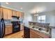 Kitchen area featuring granite countertops, stainless sink, and matching wood cabinets at 13001 Grant Cir # C, Thornton, CO 80241