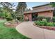 Charming brick building with beautifully landscaped walkway, lush greenery, and a welcoming entrance at 7751 S Curtice Dr # E, Littleton, CO 80120