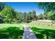Lush neighborhood walking path with mature trees and landscaped areas at 7751 S Curtice Dr # E, Littleton, CO 80120