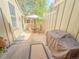 A private outdoor patio features a grill, an outdoor seating area, and lush green landscaping at 7751 S Curtice Dr # E, Littleton, CO 80120
