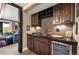 This wet bar features stone backsplash, wooden cabinets and wine storage at 1935 Bashley Rd, Monument, CO 80132