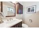 Elegant bathroom featuring a dark wood vanity, quartz countertop, and a decorative mirror at 6068 S Clayton St, Centennial, CO 80121