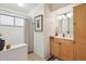 Bright bathroom featuring a wood vanity, tub with shower, and classic decor at 6068 S Clayton St, Centennial, CO 80121