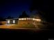 Exterior view of a modern home with a well-lit driveway at dusk with mature trees at 6068 S Clayton St, Centennial, CO 80121
