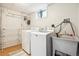 Functional laundry room with washer, dryer, sink, and wood-look floors at 6068 S Clayton St, Centennial, CO 80121