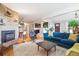 Cozy living room with a brick fireplace, hardwood floors, and a comfortable blue sofa at 6068 S Clayton St, Centennial, CO 80121