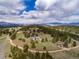 Aerial view of sprawling property nestled in a lush forest with scenic mountain views at 25803 Aspen Way, Golden, CO 80401