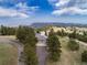 Aerial view of a stunning property surrounded by lush trees and green lawns, showcasing serene mountain views at 25803 Aspen Way, Golden, CO 80401