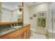 Elegant bathroom with a granite countertop, wood cabinetry, a walk-in shower, and neutral tile at 25803 Aspen Way, Golden, CO 80401
