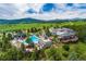 Aerial view of the community pool, tennis courts, and clubhouse surrounded by vast green lawns at 25803 Aspen Way, Golden, CO 80401