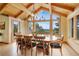 Elegant dining room with hardwood floors, a rustic chandelier, beamed ceilings, and large scenic windows at 25803 Aspen Way, Golden, CO 80401