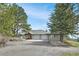 Scenic view of the driveway leading to a house with a two-car garage and beautiful trees on both sides at 25803 Aspen Way, Golden, CO 80401