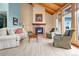 Cozy living room with hardwood floors, a fireplace, a large window, and comfortable seating at 25803 Aspen Way, Golden, CO 80401