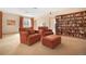 Inviting living room featuring comfortable armchairs, an ottoman, and a large built-in bookcase filled with books at 25803 Aspen Way, Golden, CO 80401