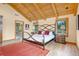 Elegant main bedroom features a wooden ceiling, hardwood floors, and a doorway to the luxurious bathroom at 25803 Aspen Way, Golden, CO 80401