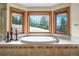 Relaxing soaking tub nestled beneath bay windows offering picturesque views of the surrounding landscape at 25803 Aspen Way, Golden, CO 80401