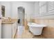 Elegant bathroom featuring a standalone tub, granite countertop, and warm neutral tile at 317 N Lafayette St, Denver, CO 80218