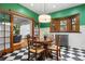 Dining area featuring a round wooden table, green walls, black and white checkered floors, and natural light at 317 N Lafayette St, Denver, CO 80218