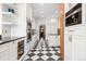 Stylish kitchen with a checkered floor, white cabinets, stainless steel appliances, and dark countertops at 317 N Lafayette St, Denver, CO 80218