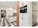 Bright kitchen featuring white cabinets, black countertops, and stainless steel appliances with a checkered floor at 317 N Lafayette St, Denver, CO 80218