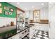 Bright kitchen with a black and white checkered floor, white cabinets, and a large kitchen island with black countertops at 317 N Lafayette St, Denver, CO 80218