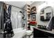 Decorated bathroom featuring a shower-tub combo, shelving, and a vintage car themed decor at 5032 Nighthawk Pkwy, Brighton, CO 80601