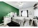 Bright bedroom featuring a ceiling fan, green accent wall, and comfortable decor at 5032 Nighthawk Pkwy, Brighton, CO 80601