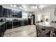 Kitchen with black appliances, modern cabinetry, and wood-look vinyl floors at 5032 Nighthawk Pkwy, Brighton, CO 80601