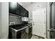 Modern laundry room with front-load washer and dryer, overhead cabinets, and a utility sink at 5032 Nighthawk Pkwy, Brighton, CO 80601