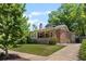 Charming brick home featuring a well-manicured lawn and a classic design under a partly cloudy sky at 864 Garfield St, Denver, CO 80206