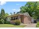 Classic brick home with a cozy front porch and a well-maintained lawn on a sunny day at 864 Garfield St, Denver, CO 80206