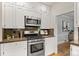 Gourmet kitchen with stainless steel range, granite countertops, and stylish white cabinetry at 864 Garfield St, Denver, CO 80206
