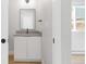 Bathroom boasts a modern vanity with sleek hardware, a framed mirror, and wood-look flooring at 4232 Jason St # 2, Denver, CO 80211