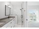 A bathroom has a frameless shower enclosure, a sink, and a view to an exterior window at 4232 Jason St # 2, Denver, CO 80211
