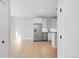 Open-concept kitchen featuring stainless steel appliances, sleek white cabinets, and light hardwood flooring at 4232 Jason St # 2, Denver, CO 80211